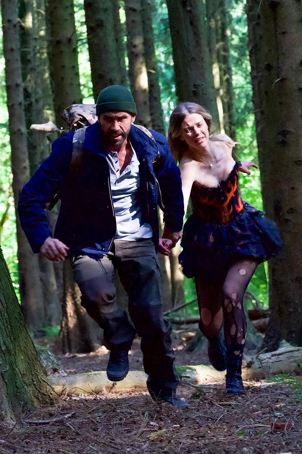 Film still of a man and a woman running through a forest